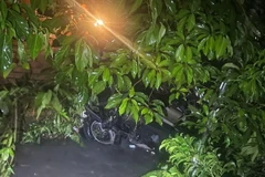 Chiếc ôtô bị nước cuốn trôi tại khu vực đường Suối Sệp, phường Tân Đông Hiệp, thành phố Dĩ An, tỉnh Bình Dương. (Ảnh: TTXVN phát)