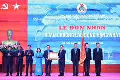 Chủ tịch Quốc hội Trần Thanh Mẫn trao Huân chương Lao động hạng Nhất cho Tổng Liên đoàn Lao động Việt Nam. (Ảnh: Minh Đức/TTXVN)