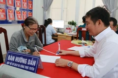 Người dân đến thực hiện thủ tục hành chính được cán bộ viên chức phường Tân Phong, thành phố Biên Hòa, hướng dẫn nhiệt tình. (Ảnh: Lê Xuân/TTXVN)