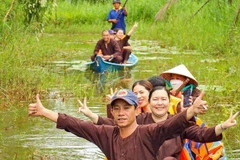 Du khách thích thú với hình thức đi xuyên rừng bằng xuồng ba lá tại điểm du lịch sinh thái ở vùng rừng U Minh hạ. (Ảnh: Huỳnh Anh/TTXVN)