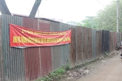 Ủy ban Nhân dân phường Xuân Đỉnh phối hợp cùng các phòng, ban của quận Bắc Từ Liêm quây rào tôn và căng băng rôn ngăn chặn đổ rác thải tại ngõ 408 Xuân Đỉnh. (Ảnh: Nguyễn Thắng/TTXVN)