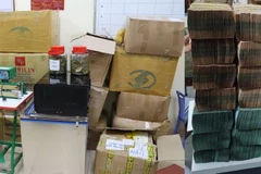 Lượng ma túy cần sa, tiền mặt và công cụ vận chuyển ma túy bị thu giữ. (Ảnh: TTXVN phát)