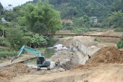 Trên công trường xây dựng kè chống sạt lở bảo vệ khu dân cư tại Bản Lạnh (xã Tân Tú) và thôn Chi Quảng B (trị trấn Phủ Thông), các kỹ sư, công nhân và máy móc đang tập trung, nhộn nhịp thi công. (Ảnh: Vũ Hoàng Giang/Vietnam+)