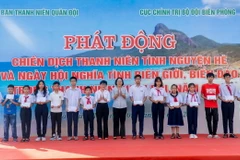 Các đại biểu tặng quà cho các cháu học sinh có hoàn cảnh khó khăn vượt khó, học giỏi. (Ảnh: Huỳnh Sơn/TTXVN)