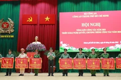 Đại tướng Tô Lâm trao cờ thi đua của Bộ Công an cho các đơn vị của Công an Thành phố Hồ Chí Minh. (Ảnh: TTXVN phát)