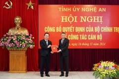 Ủy viên Bộ Chính trị, Bí thư Trung ương Đảng, Trưởng Ban Tổ chức Trung ương Lê Minh Hưng trao Quyết định cho ông Nguyễn Đức Trung, Bí thư Tỉnh ủy, Chủ tịch Ủy ban Nhân dân tỉnh Nghệ An. (Ảnh: Văn Tý/TTXVN)