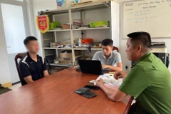 Đối tượng Phan Văn Hiếu (áo đen) tại cơ quan Công an. (Ảnh: TTXVN phát)