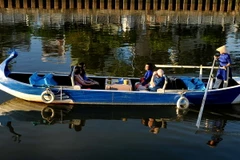 Khách du lịch quốc tế tham quan tuyến du lịch đường thủy nội đô Nhiêu Lộc-Thị Nghè bằng thuyền chèo. (Ảnh: An Hiếu/TTXVN)