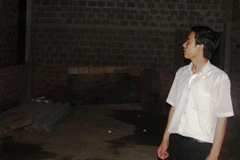 Anh Điệp quay lại nhìn nhà mình, giờ chỉ còn là đống đất hoang. (Ảnh: Xuân Dũng/Vietnam+)