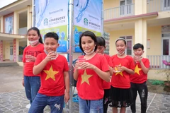 Trẻ em Trường tiểu học Minh Phú, Phú Thọ nhận nước sạch từ dự án trong ngày 21/3 vừa qua. (Ảnh: CTV/Vietnam+)