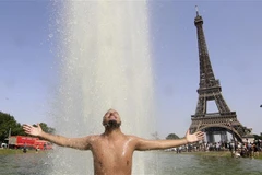 Người dân giải nhiệt tránh nắng nóng tại một đài phun nước ở Paris (Pháp), ngày 18/6/2022. (Ảnh: AFP/TTXVN)