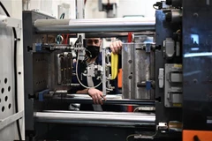 Công nhân làm việc tại nhà máy ở Trezzano sul Naviglio (Italy). (Ảnh: AFP/TTXVN)