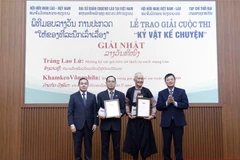 Chủ tịch Hội Hữu nghị Việt Nam-Lào Trần Văn Túy và Đại sứ Đặc mệnh toàn quyền nước Cộng hòa Dân chủ Nhân dân Lào tại Việt Nam Sengphet Houngboungnuang trao giải Nhất cho các tác giả. (Ảnh: An Đăng/TTXVN)
