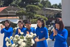 Nữ công Thành đoàn Hà Tĩnh trong trang phục áo dài truyền thống dâng hương tại Khu mộ 10 liệt sỹ thanh niên xung phong Ngã ba Đồng Lộc. (Ảnh: TTXVN phát)