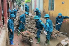 Lực lượng dân quân tự vệ huyện Mù Cang Chải và Văn Chấn tham gia khắc phục hậu quả bão số 3. (Ảnh: Tuấn Anh/TTXVN)