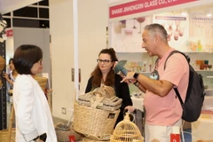 Khách nước ngoài tìm hiểu sản phẩm của Việt Nam tại hội chợ. (Ảnh: Xuân Vịnh/TTXVN)