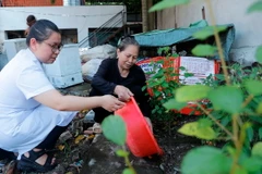 Nhân viên y tế xã Thượng Mỗ, huyện Đan Phượng, Hà Nội, hướng dẫn người dân xử lý nước thừa, nước đọng tại các vật dụng, đồ dùng sinh hoạt trong gia đình. (Ảnh: Minh Quyết/TTXVN)