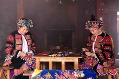Phụ nữ Lô Lô với bàn tay khéo léo thêu hoa văn trên trang phục truyền thống. (Ảnh: Trần Việt/TTXVN)