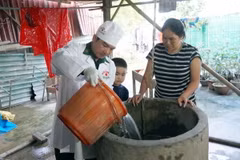 Quân y Bộ đội Biên phòng tỉnh Quảng Bình hỗ trợ người dân vùng lũ huyện Lệ Thủy khử khuẩn nguồn nước sinh hoạt. (Ảnh: TTXVN phát)