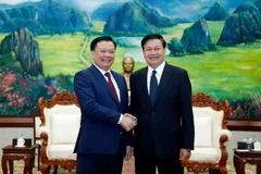 Tổng Bí thư, Chủ tịch nước Lào Thongloun Sisoulith chào đón đồng chí Đinh Tiến Dũng cùng Đoàn đến chào xã giao. (Ảnh: Phạm Kiên/TTXVN)