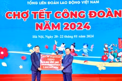Ông Đinh Tiến Dũng, Ủy viên Bộ Chính trị, Bí thư Thành ủy Hà Nội trao biển tượng trưng kinh phí tặng quà Tết cho đoàn viên, người lao động. (Ảnh: Minh Nghĩa/TTXVN)