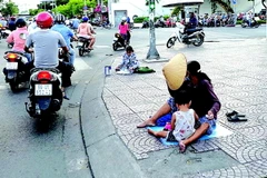 Trẻ em xin tiền ở giao lộ tại TP Hồ Chí Minh. (Ảnh: Báo Tuổi trẻ)
