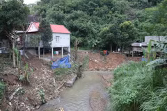 Cụm dân cư nằm trong khu vực có nguy cơ sạt lở, sụt trượt cao khi người dân xây dựng nhà ở bên bờ vực hạ nguồn khe suối. (Ảnh: Xuân Tiến/TTXVN)