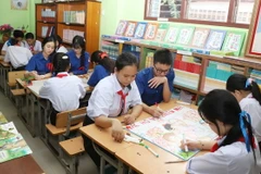 Các em học sinh người Việt và người Lào tại Trường song ngữ Lào – Việt Nam Nguyễn Du tham gia hoạt động ngoại khóa vẽ tranh Bác Hồ. (Ảnh: Xuân Tú/TTXVN)