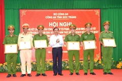 Chủ tịch UBND tỉnh Sóc Trăng Trần Văn Lâu trao Bằng khen của UBND tỉnh cho 1 tập thể và 5 cá nhân có thành tích xuất sắc trong vụ việc giải cứu con tin. (Ảnh: TTXVN phát)
