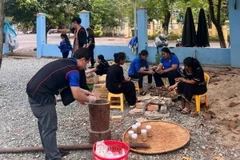 Cá muối khô giã tay được các thanh niên huyện miền núi Khánh Vĩnh thực hiện với mỗi người một công đoạn. (Ảnh: TTXVN phát)