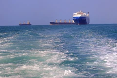 Tàu chở hàng (phải), bị lực lượng Houthi bắt giữ, trên đường về cảng tỉnh Hodeida (Yemen), ngoài khơi Biển Đỏ, ngày 22/11/2023. (Ảnh: AFP/TTXVN)