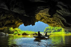 Các hang động được bao quanh bởi sông Ngô Đồng và những thảm lúa trải dài ven chân núi, đưa con người chìm đắm vào thiên nhiên. (Ảnh: Minh Đức/TTXVN)