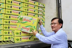 Ông Trang Công Cường, Chủ tịch UBND huyện An Phú (An Giang) đưa thùng xoài lên xe xuất đi Hàn Quốc. (Ảnh: Thanh Sang/TTXVN)