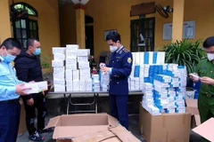 Lực lượng chức năng kiểm tra, lập biên bản lô hàng hóa nhập lậu. (Ảnh: TTXVN phát)