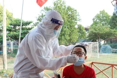 Lực lượng tình nguyện viên thành phố Buôn Ma Thuột lấy mẫu xét nghiệm test nhanh COVID-19 cho người dân để giảm áp lực cho trạm y tế xã, phường. (Ảnh: Tuấn Anh/TTXVN)