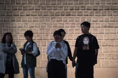 Một nhóm các bạn trẻ sử dụng điện thoại di động tại Seoul, Hàn Quốc. (Nguồn: AFP/TTXVN)