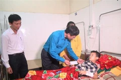 Đoàn công tác chuyển lời chia sẻ, quà của Bộ trưởng Bộ Giáo dục và Đào tạo Phùng Xuân Nhạ đến các nạn nhân. (Ảnh: Khiếu Tư/TTXVN)