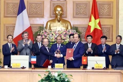 Bộ trưởng, Chủ nhiệm Văn phòng Chính phủ Mai Tiến Dũng (bên phải) và Ngài Jean-Pierre Marcelli, Giám đốc điều hành Cơ quan Phát triển Pháp (AFD) ký kết Bản ghi nhớ hợp tác. (Ảnh: Thống Nhất/TTXVN)