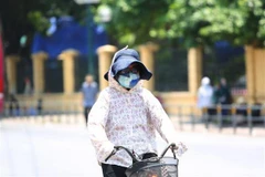 Người dân thủ đô chống chọi với nắng nóng bằng trang phục kín mít. (Ảnh: Thành Đạt/TTXVN)