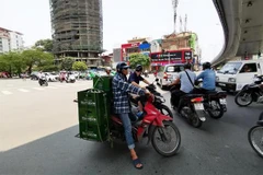 Tránh nắng dưới gầm cầu ảnh hưởng đến các phương tiện đang tham gia giao thông. (Ảnh: Thành Đạt/TTXVN)