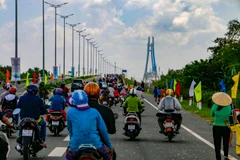 Người dân lưu thông qua cầu Vàm Cống sau khi thông xe. (Ảnh: Thanh Liêm/TTXVN)