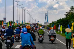 Người dân lưu thông qua cầu Vàm Cống sau khi thông xe. (Ảnh: Thanh Liêm/TTXVN)
