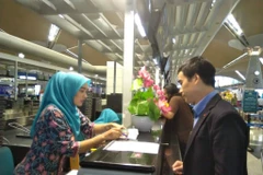 Cán bộ Đại sứ quán Việt Nam hỗ trợ làm thủ tục check-in cho Đoàn Thị Hương lên tàu bay từ Kuala Lumpur về Hà Nội. Dự kiến máy bay sẽ hạ cánh xuống sân bay Nội Bài lúc 9 giờ 30 tối cùng ngày. (Ảnh: Hà Ngọc/TTXVN)