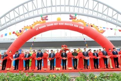 Các đại biểu cắt băng khánh thành nút giao Nguyễn Văn Linh. (Ảnh: An Đăng/TTXVN)