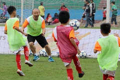 Huấn luyện viên Park Hang Seo vui vẻ chơi bóng cùng các em học sinh. (Ảnh: Trung Kiên/TTXVN)