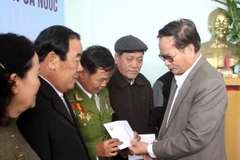 Ông Lê Xuân Tánh (phải) - Chủ tịch hội Chiến sỹ Thành cổ Quảng Trị - trao quà cho các hội viên. (Ảnh: Trịnh Bang Nhiệm/TTXVN)