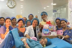Ban giám đốc, êkíp trực đêm tại Bệnh viện Từ Dũ tặng quà cho sản phụ sinh con đầu tiên trong năm 2020. (Ảnh: Đinh Hằng/TTXVN)