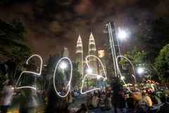 Người dân đón thời khắc giao thừa trong lễ hội năm mới ở tòa tháp đôi Petronas, Kuala Lumpur, Malaysia. (Ảnh: THX/TTXVN)