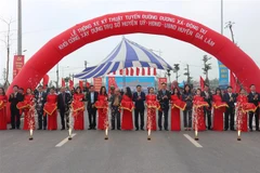 Các đại biểu thực hiện nghi thức cắt băng thông xe tuyến đường. (Ảnh: Mạnh Khánh/TTXVN)