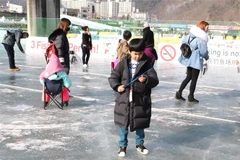 Một em nhỏ đang câu cá trên băng. (Ảnh: Mạnh Hùng/TTXVN)